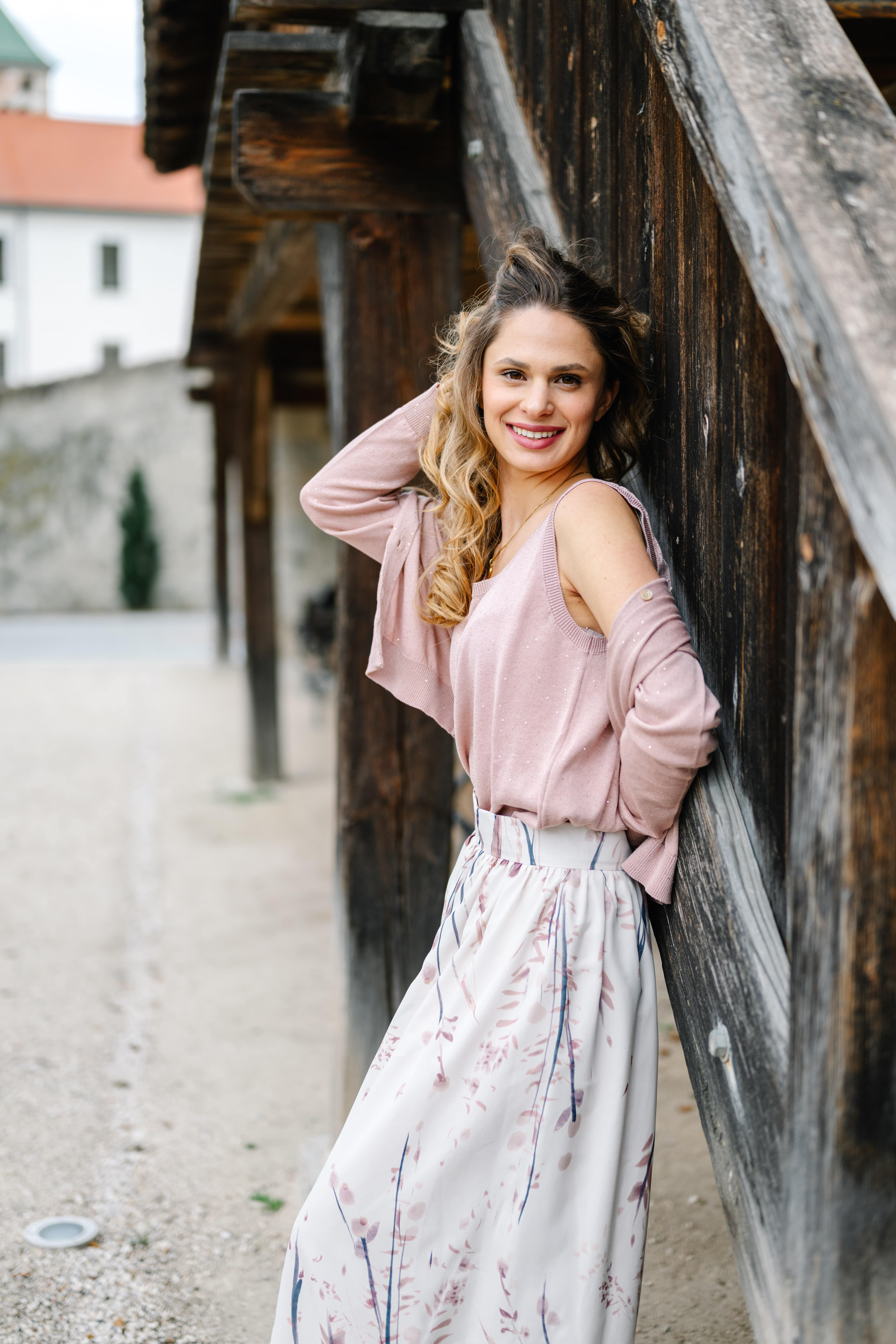 Frau mit rosafarbener Bluse und hellem Rock